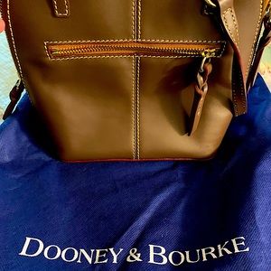 2 never used Dooney & Bourke handbags.  Come with storage bags and cards.